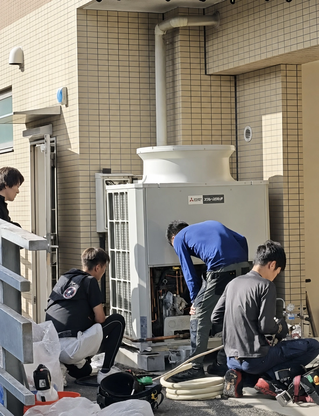厚木市近郊で業務用空調室外機を施工する複数名の技術者